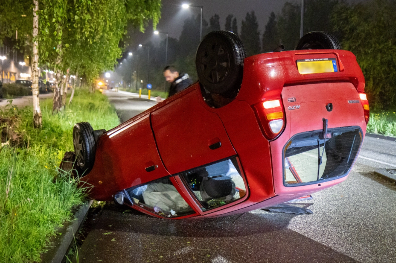 Auto ramt boom en belandt op dak